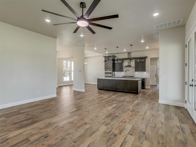 5812 Cimarron Mnr, Guthrie, OK 73044 - kitchen with ceiling fan, open floor plan, wood finished floors, a center island with sink, and recessed lighting