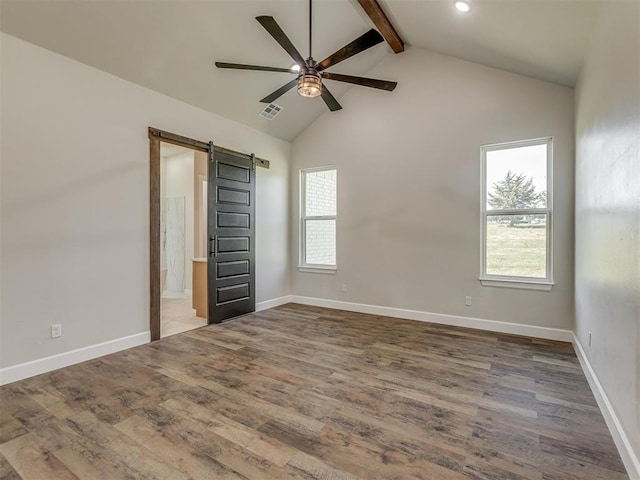 5812 Cimarron Mnr, Guthrie, OK 73044 - spare room with a barn door, beamed ceiling, ceiling fan, wood finished floors, and high vaulted ceiling