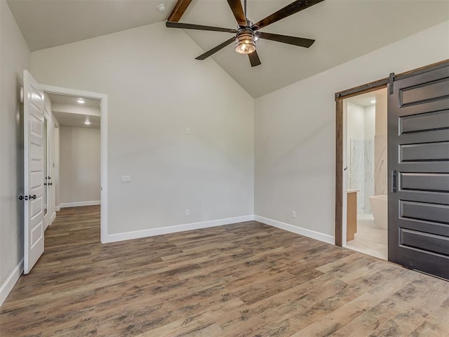 5812 Cimarron Mnr, Guthrie, OK 73044 - unfurnished bedroom with wood finished floors, high vaulted ceiling, beam ceiling, a barn door, and recessed lighting