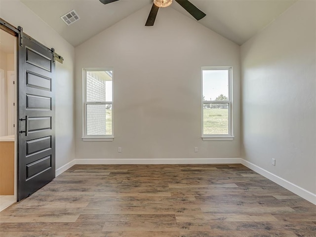 5812 Cimarron Mnr, Guthrie, OK 73044 - unfurnished room featuring a barn door, a ceiling fan, healthy amount of natural light, lofted ceiling, and wood finished floors