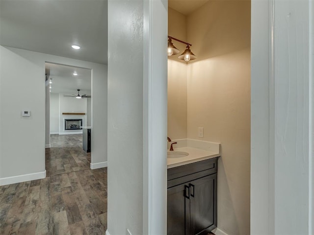 5812 Cimarron Mnr, Guthrie, OK 73044 - bathroom featuring vanity, wood finished floors, recessed lighting, ceiling fan, and a fireplace