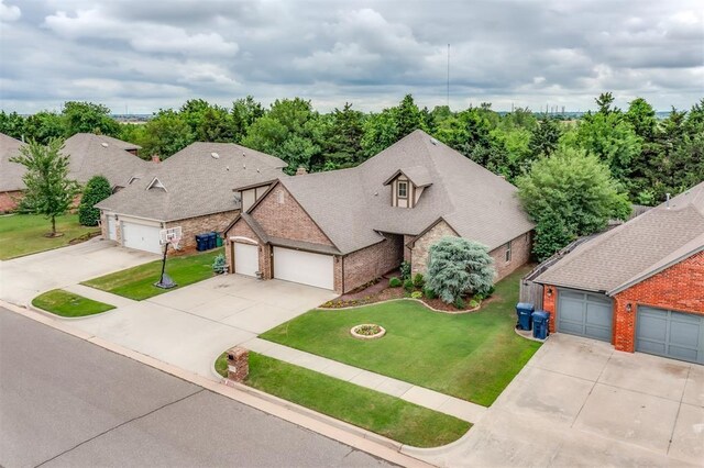 328 SW 175th Ter, Oklahoma City, OK 73170 - view of front of house featuring concrete driveway, a front yard, stone siding, a garage, and roof with shingles