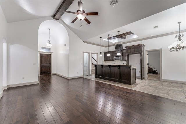 328 SW 175th Ter, Oklahoma City, OK 73170 - unfurnished living room featuring arched walkways, ceiling fan, high vaulted ceiling, beamed ceiling, and wood-type flooring