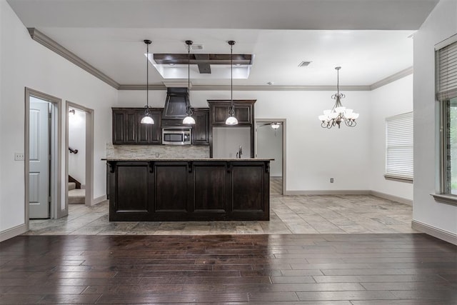 328 SW 175th Ter, Oklahoma City, OK 73170 - kitchen with stainless steel microwave, light wood finished floors, a chandelier, dark brown cabinetry, and tasteful backsplash