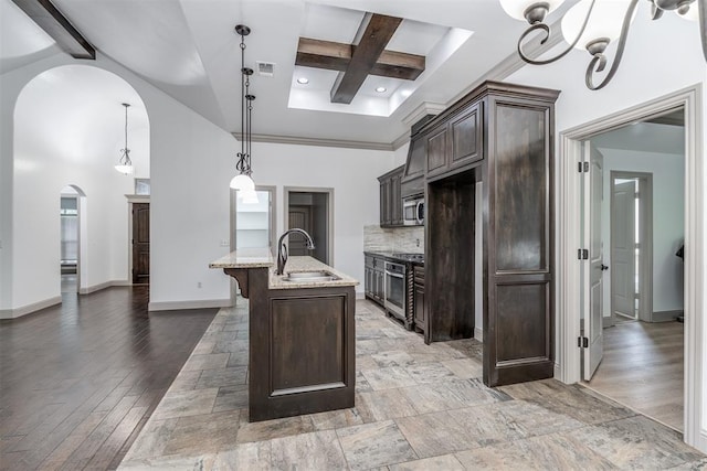 328 SW 175th Ter, Oklahoma City, OK 73170 - kitchen featuring a sink, range, stainless steel microwave, dark brown cabinets, and arched walkways