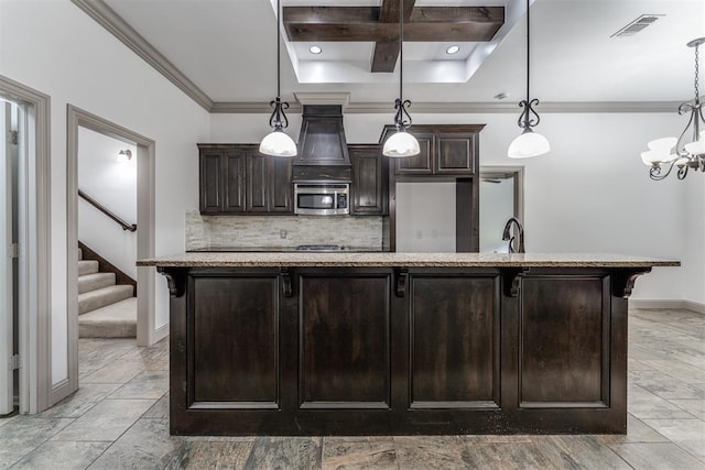 328 SW 175th Ter, Oklahoma City, OK 73170 - kitchen featuring stainless steel microwave, coffered ceiling, backsplash, dark brown cabinets, and a chandelier