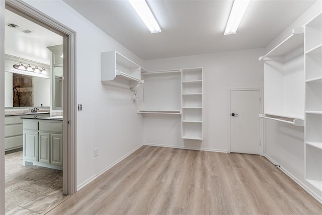 328 SW 175th Ter, Oklahoma City, OK 73170 - walk in closet featuring light wood-style flooring and a sink
