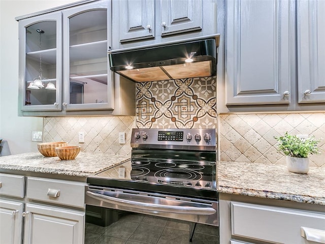 113 Stone Creek Dr, Midwest City, OK 73130 - kitchen with stainless steel range with electric cooktop, exhaust hood, glass insert cabinets, tile patterned floors, and backsplash