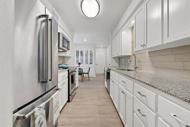 7802 Old Hickory Ln, Oklahoma City, OK 73116 - kitchen with appliances with stainless steel finishes, a sink, white cabinetry, tasteful backsplash, and recessed lighting