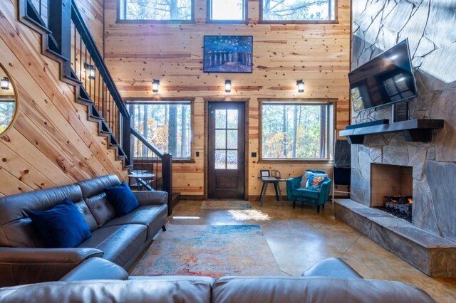 59 Sweet Elm, Broken Bow, OK 74728 - living area with wood walls, a towering ceiling, stairway, finished concrete flooring, and a fireplace