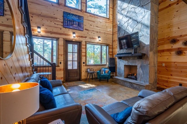 59 Sweet Elm, Broken Bow, OK 74728 - living area with wood walls, a stone fireplace, stairway, and a towering ceiling