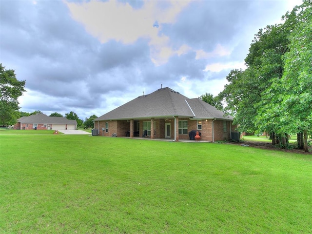16441 Roserock Cir, Choctaw, OK 73020 - rear view of house with a yard, brick siding, central air condition unit, and a patio area