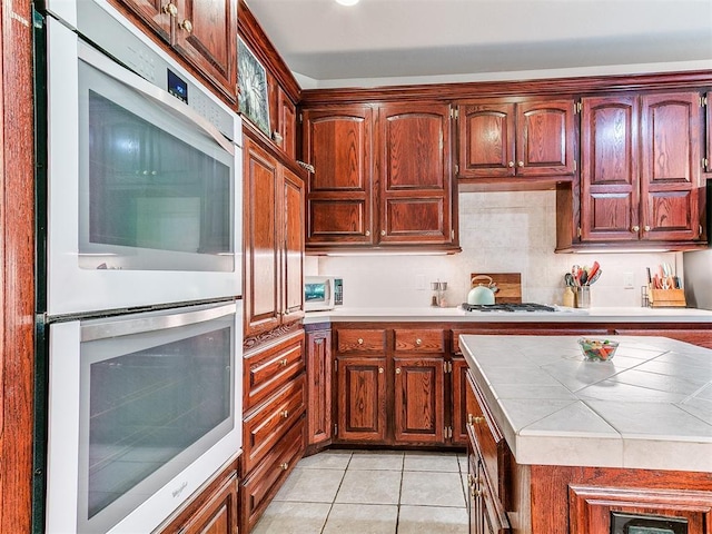 16441 Roserock Cir, Choctaw, OK 73020 - kitchen featuring double oven, tile countertops, light tile patterned flooring, and gas stovetop