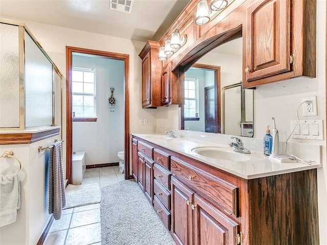 16441 Roserock Cir, Choctaw, OK 73020 - bathroom with double vanity, toilet, plenty of natural light, and tile patterned flooring