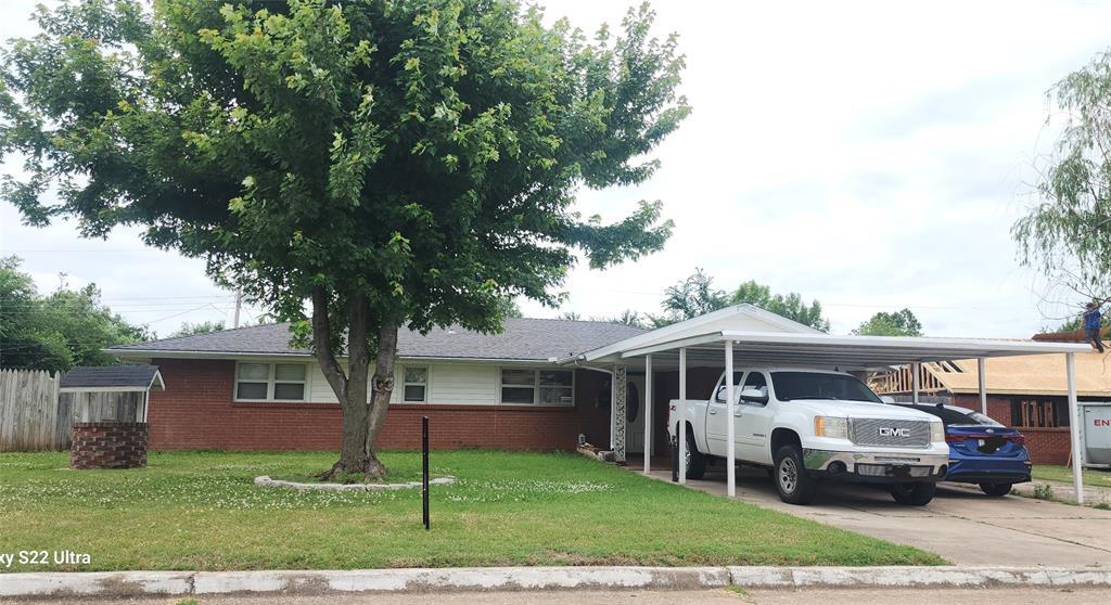 920 Arthur Dr, Oklahoma City, OK 73110 - view of front facade with a carport, a front yard, brick siding, and driveway