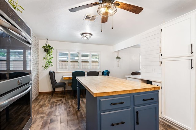 1113 Winnipeg Dr, Yukon, OK 73099 - kitchen with butcher block countertops, blue cabinetry, white cabinetry, a ceiling fan, and dark wood-style floors
