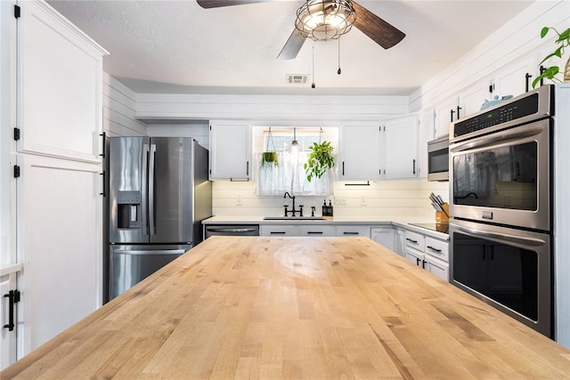 1113 Winnipeg Dr, Yukon, OK 73099 - kitchen featuring stainless steel appliances, a sink, wooden counters, and a ceiling fan