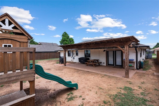 1113 Winnipeg Dr, Yukon, OK 73099 - rear view of property featuring brick siding, a patio area, a playground, and cooling unit