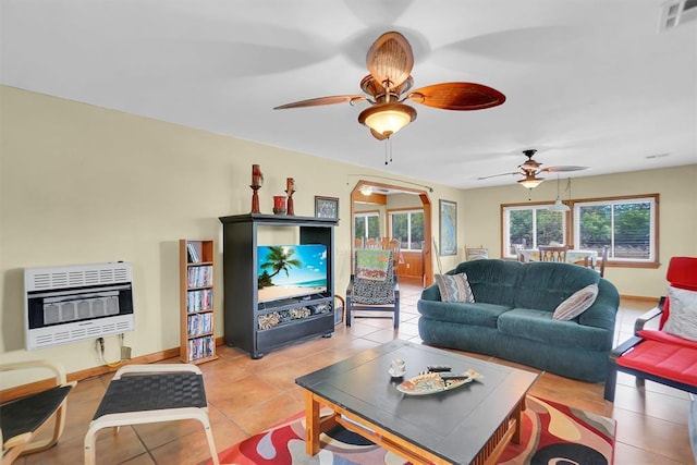 23596 Beach Haven Dr, Granite, OK 73547 - living room featuring heating unit, ceiling fan, light tile patterned floors, baseboards, and arched walkways