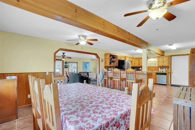 23596 Beach Haven Dr, Granite, OK 73547 - dining area featuring a ceiling fan, a wainscoted wall, light tile patterned flooring, beam ceiling, and wood walls
