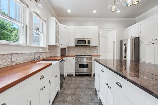 430 W Symmes St, Norman, OK 73069 - kitchen with stainless steel appliances, a sink, white cabinets, decorative backsplash, and stone finish flooring