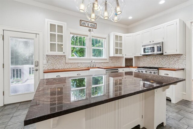 430 W Symmes St, Norman, OK 73069 - kitchen with stainless steel microwave, a chandelier, white cabinetry, a sink, and crown molding
