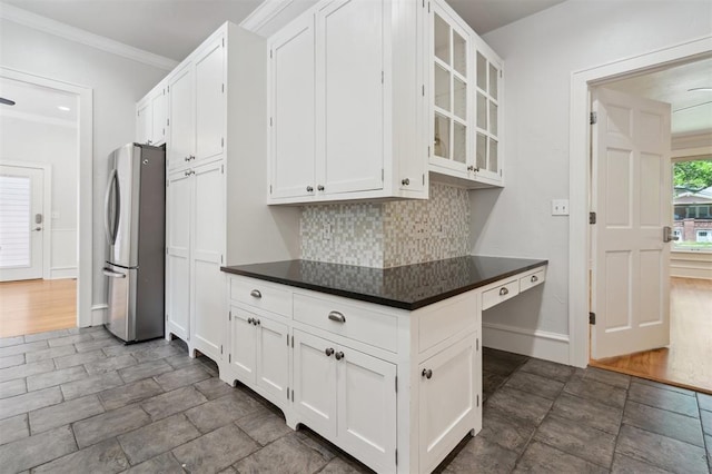 430 W Symmes St, Norman, OK 73069 - kitchen with freestanding refrigerator, backsplash, white cabinets, dark countertops, and glass insert cabinets