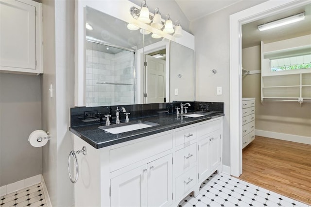 430 W Symmes St, Norman, OK 73069 - bathroom featuring double vanity, tiled shower, and baseboards