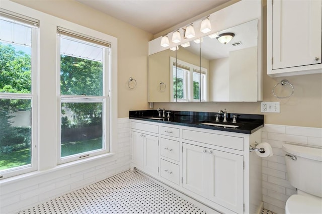 430 W Symmes St, Norman, OK 73069 - full bathroom with a wainscoted wall, tile walls, toilet, and double vanity
