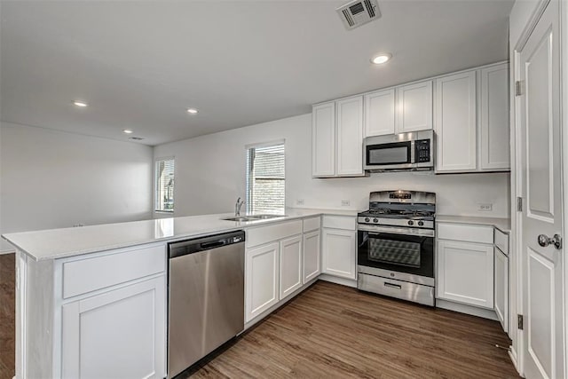 3717 Palmetto Bluff Dr, Mustang, OK 73064 - kitchen featuring stainless steel appliances, a peninsula, a sink, white cabinets, and light countertops