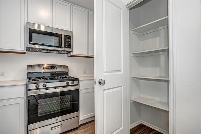 3717 Palmetto Bluff Dr, Mustang, OK 73064 - kitchen featuring appliances with stainless steel finishes, light countertops, light wood-type flooring, and white cabinetry