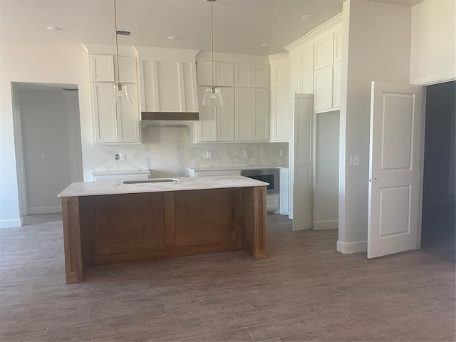 5100 Misty Wood Ln, Mustang, OK 73064 - kitchen with white cabinetry, a kitchen island, decorative backsplash, and wood finished floors