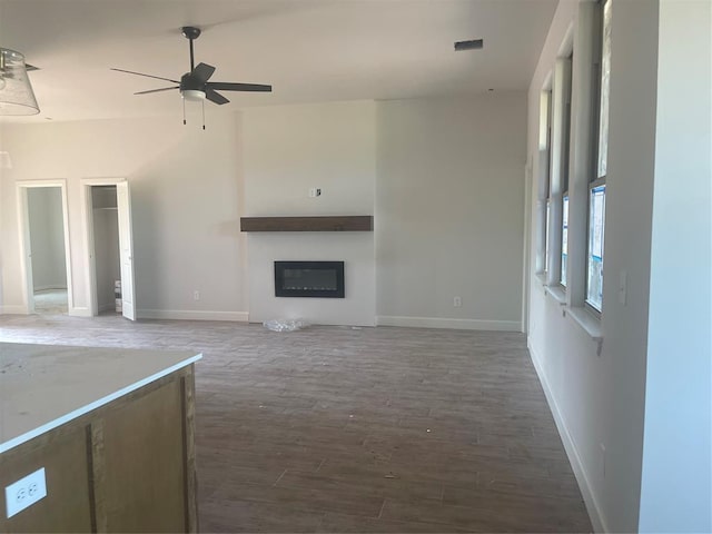 5100 Misty Wood Ln, Mustang, OK 73064 - unfurnished living room featuring a ceiling fan, wood finished floors, and a glass covered fireplace