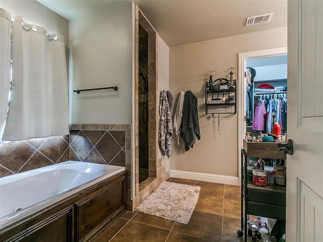15508 Homecoming Dr, Edmond, OK 73013 - full bathroom featuring a bath, tile patterned flooring, a stall shower, a walk in closet, and baseboards
