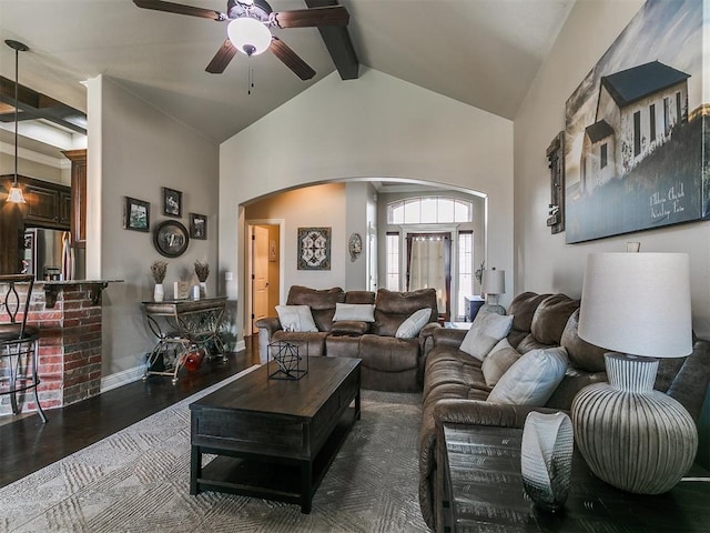 15508 Homecoming Dr, Edmond, OK 73013 - living room with arched walkways, a ceiling fan, beamed ceiling, wood finished floors, and baseboards