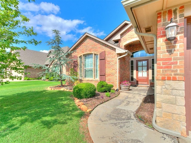 15508 Homecoming Dr, Edmond, OK 73013 - view of exterior entry with brick siding and a yard