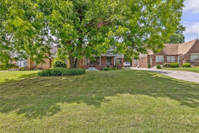 938 NE 21st St, Oklahoma City, OK 73105 - view of front of property with brick siding, a front lawn, driveway, and covered porch