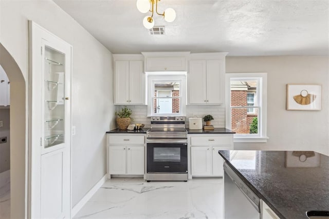 938 NE 21st St, Oklahoma City, OK 73105 - kitchen with appliances with stainless steel finishes, arched walkways, healthy amount of natural light, and decorative backsplash