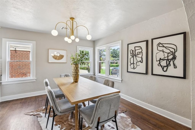 938 NE 21st St, Oklahoma City, OK 73105 - dining space with baseboards, wood finished floors, a chandelier, and a textured wall
