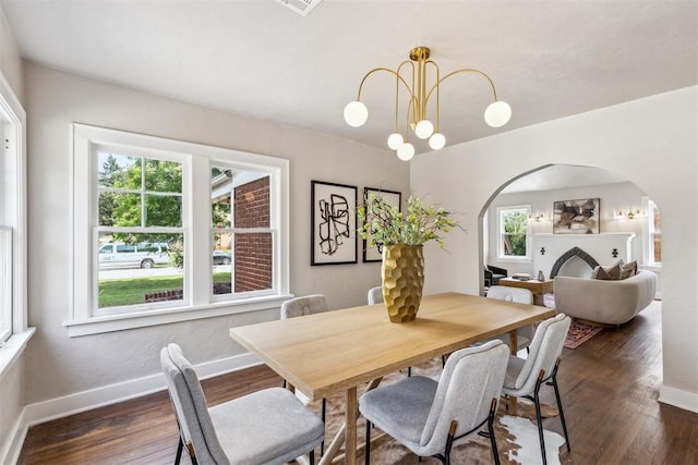938 NE 21st St, Oklahoma City, OK 73105 - dining space featuring arched walkways, healthy amount of natural light, dark wood-type flooring, and baseboards