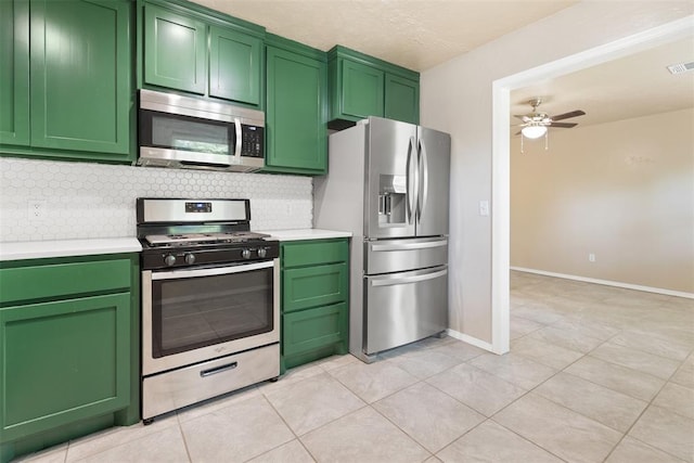 1221 NW 101st St, Oklahoma City, OK 73114 - kitchen with stainless steel appliances, green cabinets, decorative backsplash, light countertops, and a ceiling fan