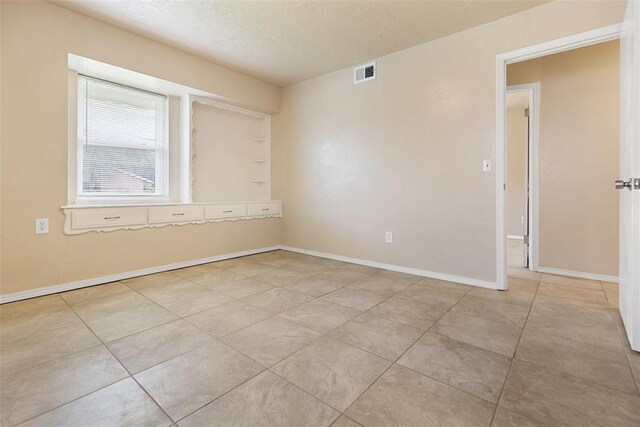 1221 NW 101st St, Oklahoma City, OK 73114 - tiled spare room with a textured ceiling and baseboards