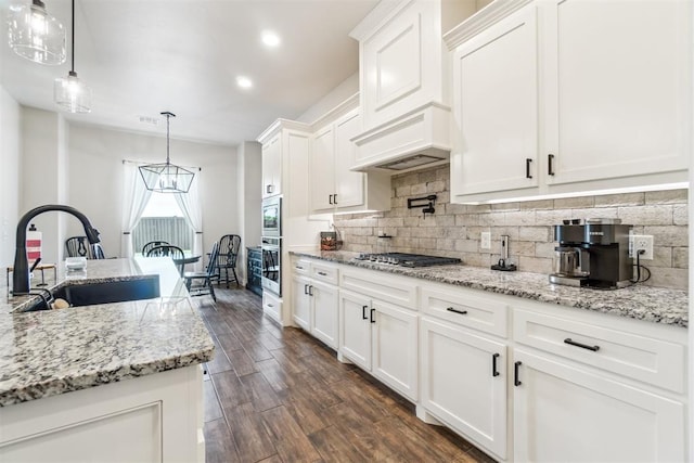 4442 Violet St, Tuttle, OK 73089 - kitchen with a sink, appliances with stainless steel finishes, white cabinets, decorative backsplash, and dark wood finished floors