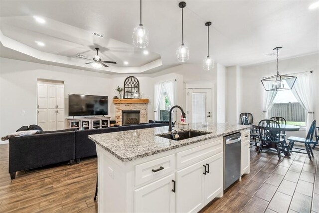 4442 Violet St, Tuttle, OK 73089 - kitchen featuring dishwasher, a sink, a kitchen island with sink, ceiling fan, and a tray ceiling