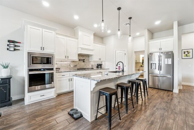 4442 Violet St, Tuttle, OK 73089 - kitchen with stainless steel appliances, a sink, dark wood-type flooring, decorative backsplash, and white cabinetry