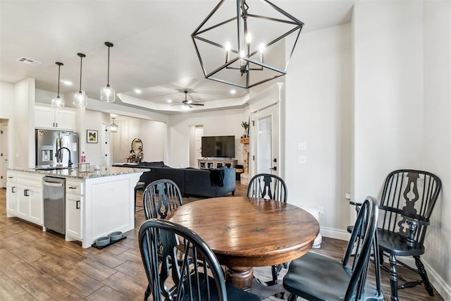 4442 Violet St, Tuttle, OK 73089 - dining room featuring ceiling fan, dark wood-style floors, baseboards, and a raised ceiling