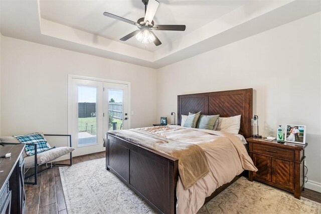 4442 Violet St, Tuttle, OK 73089 - bedroom featuring a tray ceiling, access to exterior, light wood-style floors, and ceiling fan