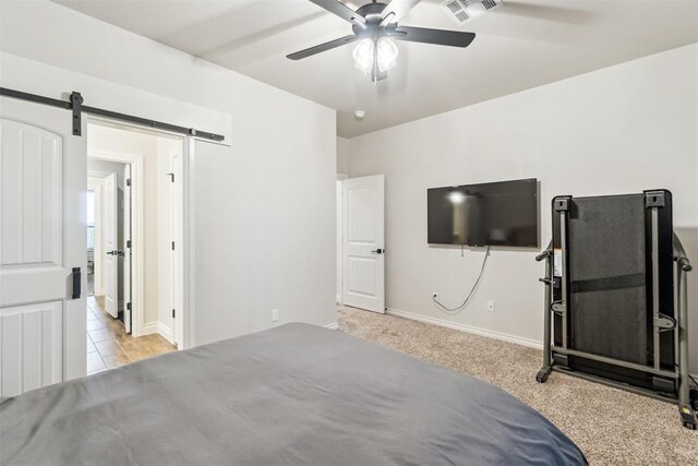 4442 Violet St, Tuttle, OK 73089 - unfurnished bedroom with a barn door, baseboards, carpet flooring, and a ceiling fan