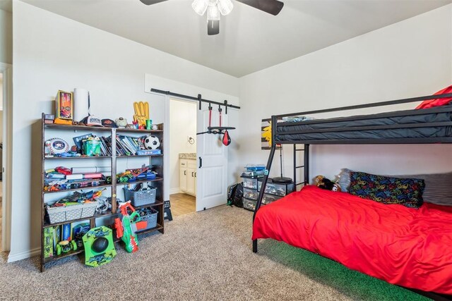 4442 Violet St, Tuttle, OK 73089 - carpeted bedroom featuring a barn door, ensuite bathroom, a ceiling fan, and baseboards