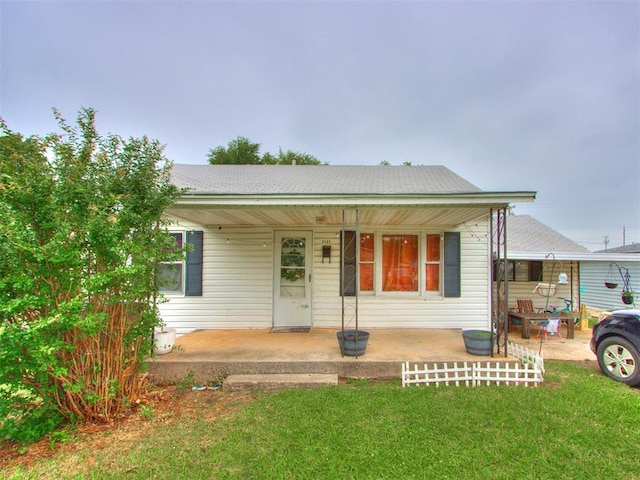 2133 SW 46th St, Oklahoma City, OK 73119 - view of front facade featuring covered porch, a front lawn, and a shingled roof
